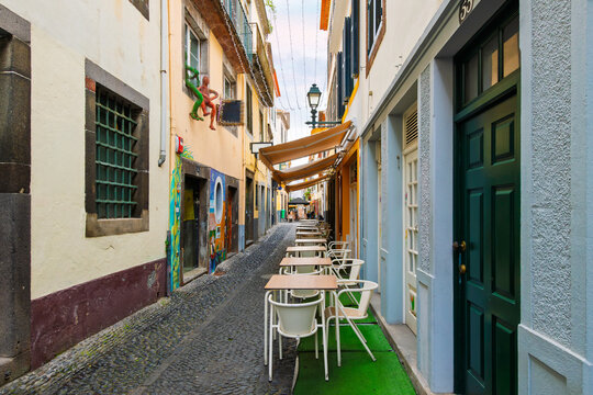 The famous Rua de Santa Maria narrow street of sidewalk cafes, colorful doors and shops in the historic medieval old town of Funchal, Madeira Island, Portugal.