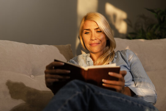 Woman Reading a Book While Relaxing at Home During a Digital Detox in the Afternoon Light