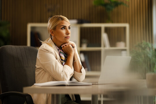 Woman Working in a Small Office Thinking About Business Strategy During the Day