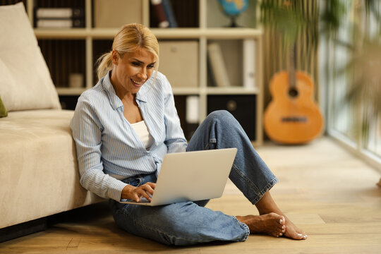 Woman Works on Laptop in Small Office at Home During Daytime Focusing on Freelancing Tasks
