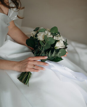 Bride in White Dress Showing Wedding Ring with White Rose Bouquet