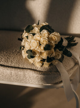 Elegant Bridal Bouquet of Cream Roses and Eucalyptus on Armchair