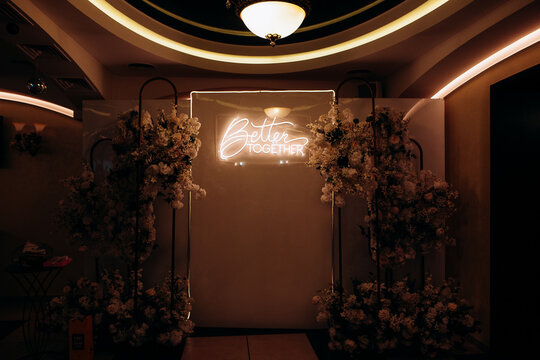 Wedding Photo Backdrop with "Better Together" Neon Sign and Flowers