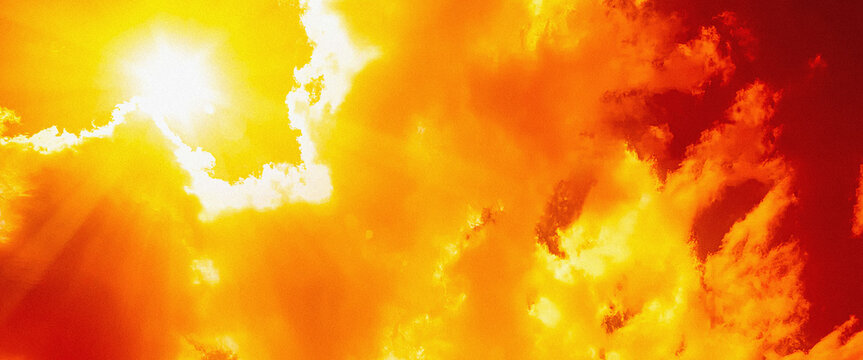 Extreme heatwave glaring sun rays piercing through hot red and orange clouds