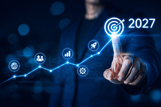 Business person touching a glowing digital chart with a 2027 target, symbolizing future growth and success.