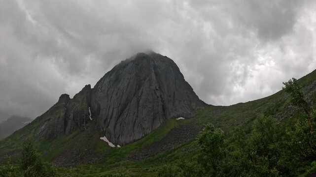 Static wide view of iconic Segla mountain peak shrouded in mist in Senja Norway