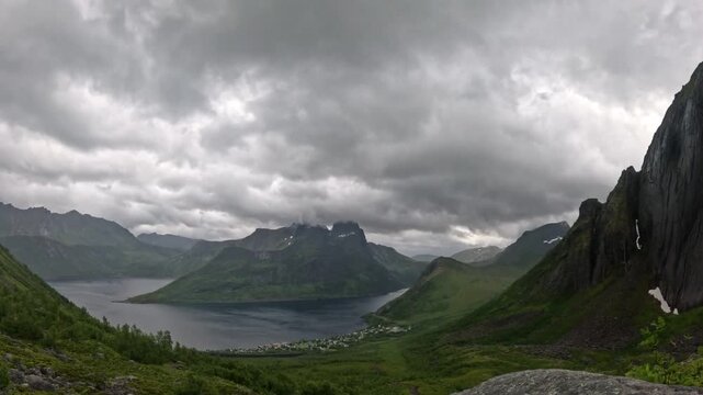 Ultra wide static panorama of Norwegian fjord village and Segla cliff face in Senja