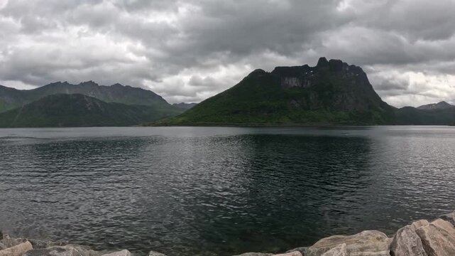 Static ultra wide view of Segla mountain peak across fjord from Fjordgard breakwater Norway