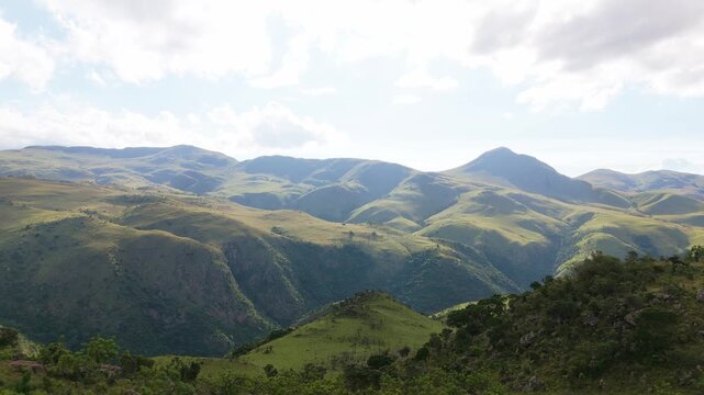 Sideways drone flight captures verdant Swaziland highlands under golden evening sky, highlighting dramatic ridges and surreal landscapes. Evokes exploration, wilderness, and cinematic travel for edito