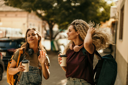 Friends traveling city street enjoying coffee and exploring
