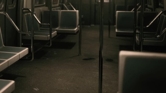 The subway train is empty with rows of seats. The lights are dim, and the floor shows signs of wear. The scene captures the stillness during a quiet time.