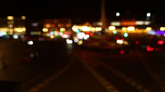 Nighttime scene of a city street with blurred traffic and lights