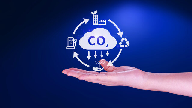 Hand holding CO2 reducing virtual icon for decrease carbon dioxide emission, carbon footprint and carbon credit to limit global warming from Bio climate change concept.