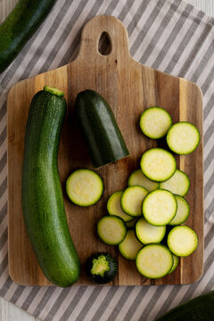 Raw Green Organic Zucchini on a Wooden Board, top view.