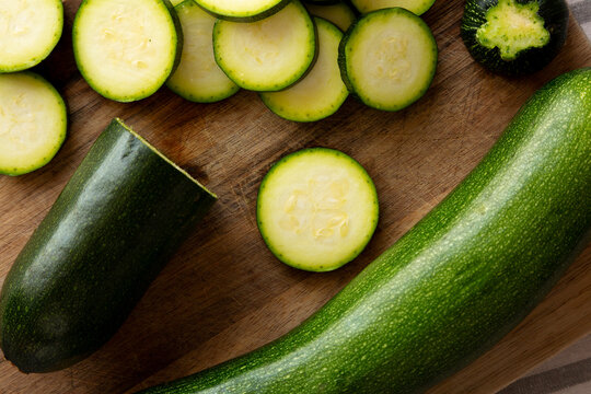 Raw Green Organic Zucchini on a Wooden Board, top view. Flat lay, overhead, from above.
