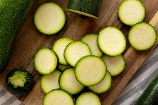 Raw Green Organic Zucchini on a Wooden Board, top view. Flat lay, overhead, from above.