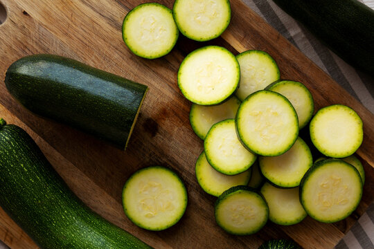 Raw Green Organic Zucchini on a Wooden Board, top view. Flat lay, overhead, from above.