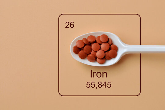 Iron Supplement Pills in Spoon with Fe Element Symbol