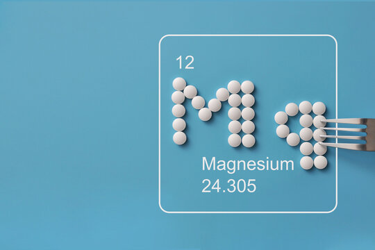 Magnesium Mg Symbol Made from White Pills on Blue Background
