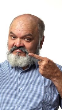 An Indian Asian elderly businessman with a beard is enjoying an apple, highlighting its health benefits gesturing with hands