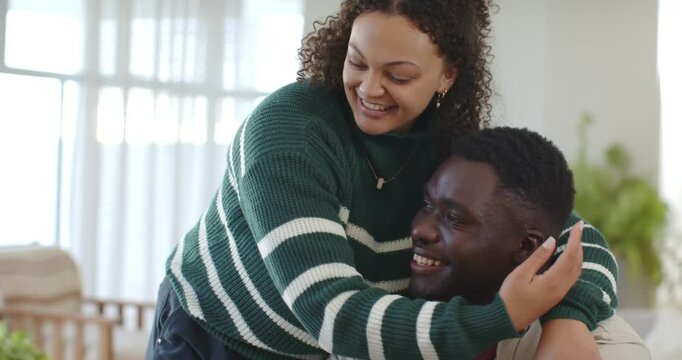 Couple smiling and leaning, hugging while man picking up tablet, checking content at wooden table