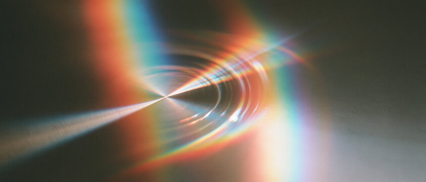 Rainbow light streaks reflecting on dark abstract background