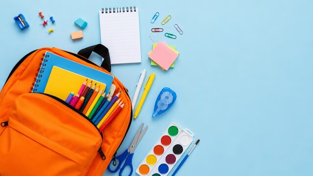 Orange bag and school items rest on a light blue surface, seen from above.