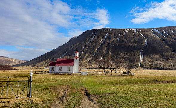 Historic Bolstadarhidarkirkja church standing in a vast valley mountain under a blue sky. Icelandic churches. Place of worship Iceland landscape