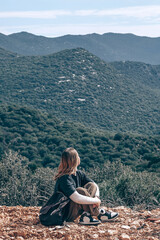 Fototapeta premium Solo female traveler hiking in coastal mountains with a backpack, embracing adventure travel, nature immersion, active tourism, freedom, wellness and mindful outdoor exploration.