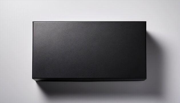 top down view of a closed matte black rectangular box on a white surface with a soft shadow