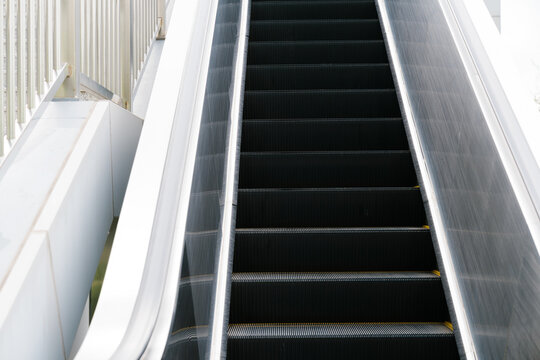 Empty escalator staircase conveys sense of quiet stillness and peaceful emptiness inside modern building with clean architectural lines