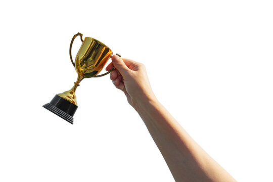 Hand holds and raised small cup trophy, holding cup isolated on free background. Consolation prize award and victory concept.
