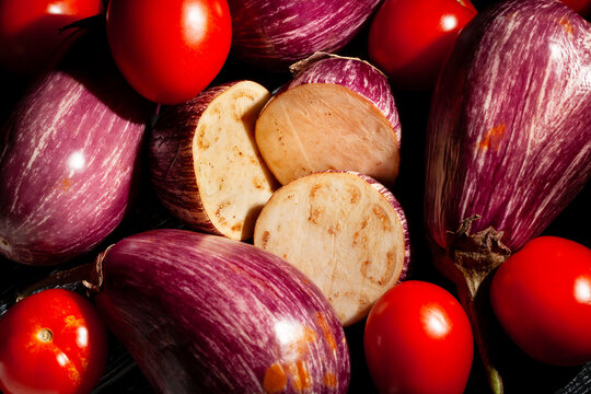 sliced jewel marble eggplant tomato mix on black top view