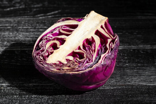 sliced red cabbage on black wood background