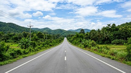 Fototapeta premium Endless Tropical Road Under a Cloudy Sky Journeying Through Lush Green Mountains