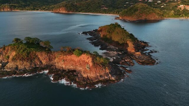 4K Aerial drone view of Playa Penca rocky coast at sunset, Costa Rica