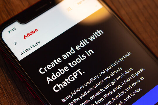 Mexico City, MEXICO - Aug 12 2026 : Close-up of a smartphone showing an Adobe Firefly page headlined create and edit with Adobe tools in ChatGPT, listing Photoshop, Adobe Express and Acrobat.