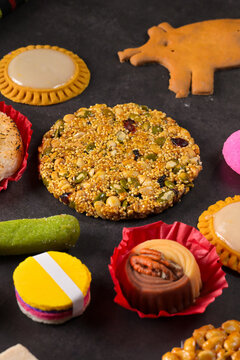 Overhead view of a vibrant assortment of hand-crafted Mexican sweets like borrachitos, alegrías, and palanquetas on a dark surface