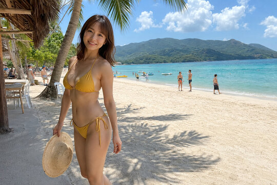 麦わら帽子を持つ黄色ビキニの女性