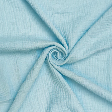 Soft light blue cotton fabric gently folded into a spiral shape close up textile background muslin cloth texture pastel blue fabric nursery bedding blanket material soft surface home decor fashion