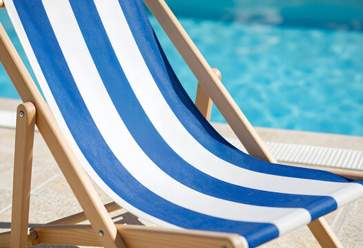 Blue and white striped deck chair by a swimming pool, summer vacation and relaxation