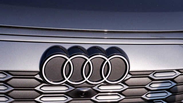 Leicester, England, UK - 17 July 2026: Audi, logo, emblem, car, grille, front, vehicle badge on modern silver automobile exterior close up