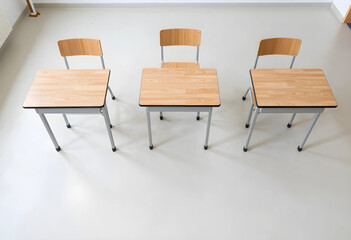 Obraz premium Three empty wooden school desks and chairs in a classroom, education and learning environment, social distancing