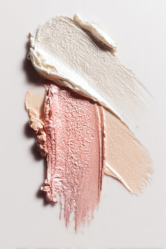 Cosmetic samples swatching different colors and textures of make up pigments on a white background, highlighting beauty products