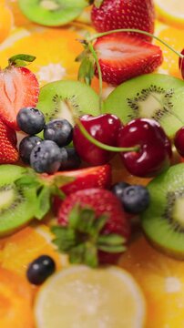 Background of fresh fruits and berries rotating. Vegan sweet food, flat lay.
