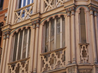 Elegant Neo-Mudejar Building Facade with Curved Bay Windows and Shutters © Ena