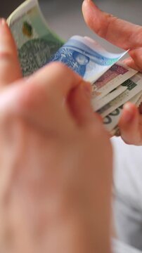 Female hands carefully counting polish zloty banknotes
