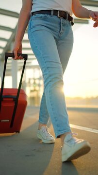 Woman confidently pulling a suitcase in an airport terminal. Slow motion.