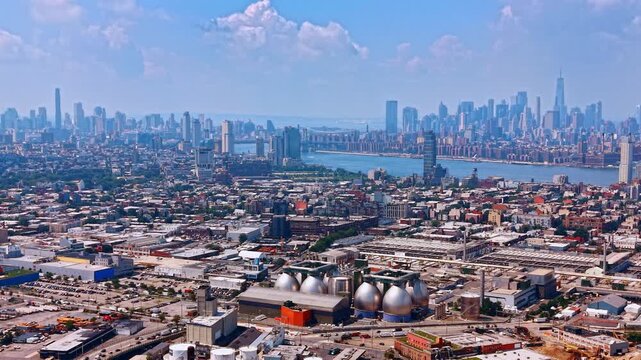Vast industrialized area of Brooklyn and Queens crossed by Newton Creek. New York City panorama from drone descending over the scenery.
