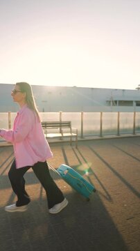 Caucasian woman pulling a suitcase and running, late for flight. Side view